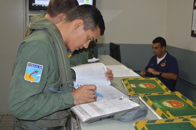 Foco: Aspirante conferindo plano de voo antes de se dirigir para a aeronave