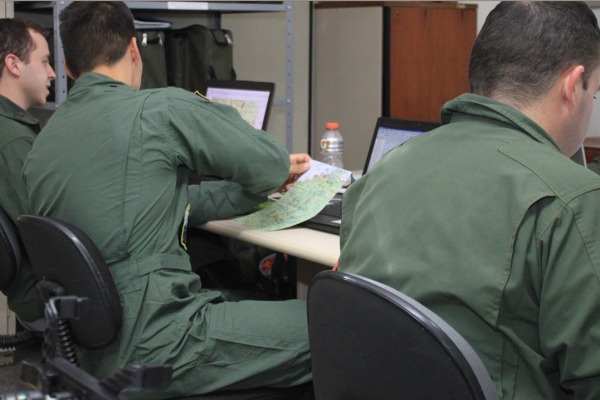 Pilotos realizando planejamento para a missão