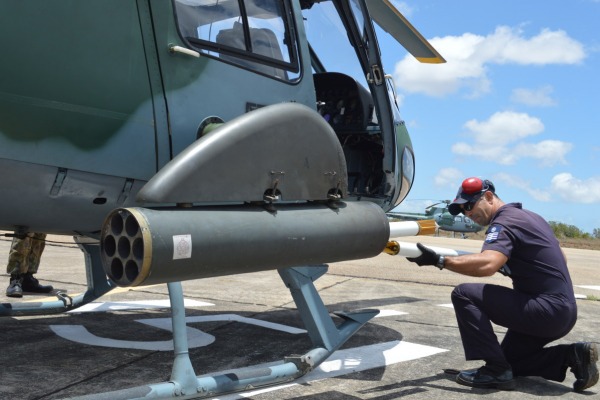 Militar prepara armamento no helicóptero