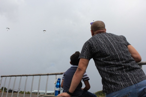 Pai e filho observam salto de paraquedistas na Ala 7 em Boa Vista (RR)