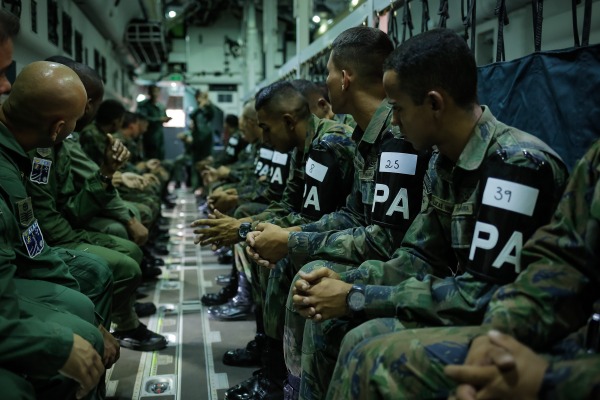 Militares aguardam para realizar a evacuação pela escotilha do avião